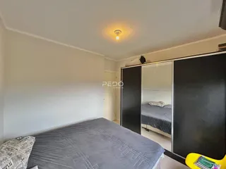 Quarto com cama e armário embutido em um ambiente claro.