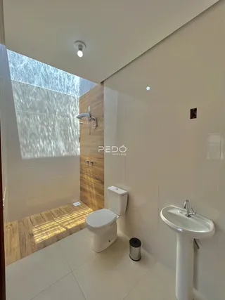 Banheiro moderno com revestimento de madeira e piso claro.