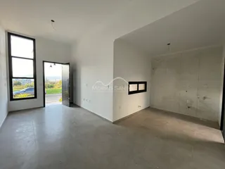 Ambiente interno amplo com piso de cerâmica e janela com vista externa.