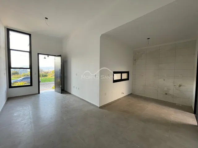 Ambiente interno amplo com piso de cerâmica e janela com vista externa.