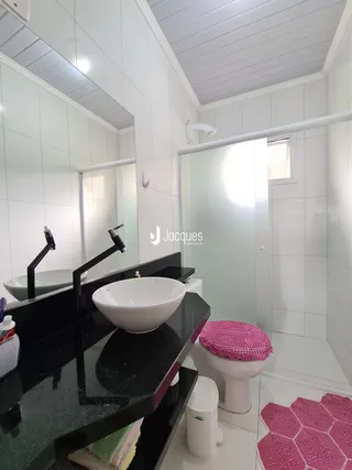 Foto de um banheiro moderno com revestimento branco e bancada escura.