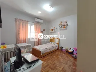 Quarto com cama e cortinas em ambiente interno.