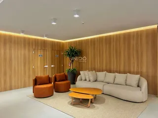 Sala de estar moderna com sofá e poltronas alaranjadas em um ambiente com painel de madeira.