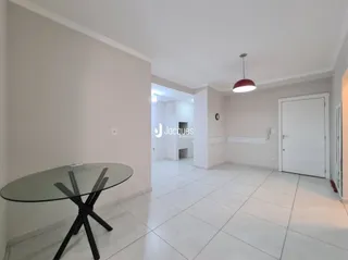 Ambiente interno com piso de cerâmica e mesa de vidro.