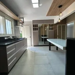 Foto de uma cozinha moderna com armários escuros e piso claro.