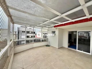 Vista de uma área externa coberta com piso de cerâmica e grade de proteção.