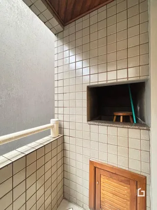 Parede interna com revestimento de azulejos e porta de madeira.