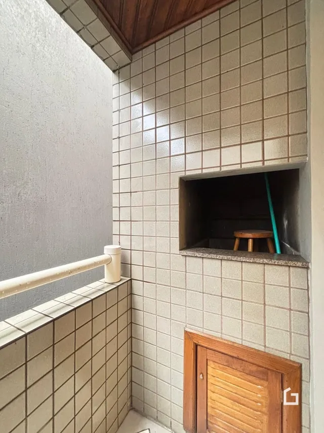 Parede interna com revestimento de azulejos e porta de madeira.