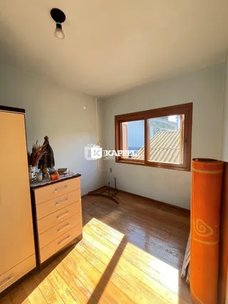 Foto de um cômodo interno com piso de madeira e janela.