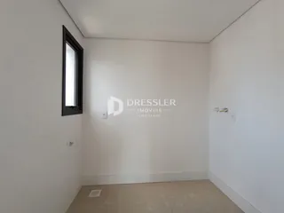 Vista interna de um ambiente com paredes brancas e piso claro.
