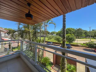 Vista da varanda com vegetação tropical e palmeiras.