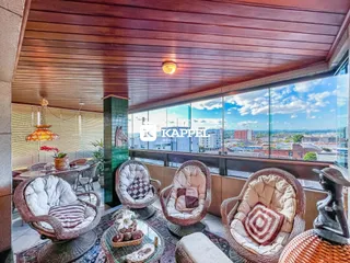 Sala com móveis de vime e vista panorâmica da cidade.