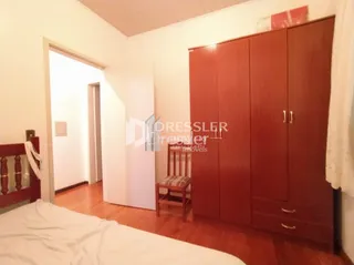 Quarto com armários em madeira e piso de madeira.