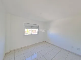 Sala de estar com piso de cerâmica clara e janela.