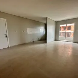 Foto de um ambiente interno amplo e vazio com piso claro.