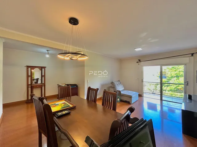 Sala de jantar com piso de madeira e porta de vidro abrindo para o exterior.