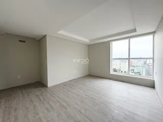 Ambiente interno de um imóvel com paredes brancas e piso claro.