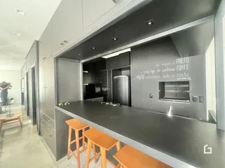 Uma cozinha moderna com armários cinzas e ilha central.