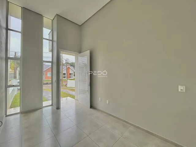 Vista interna de um ambiente com piso de cerâmica e grandes janelas.