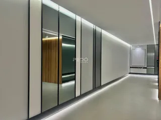 Um corredor moderno com paredes espelhadas e piso claro.