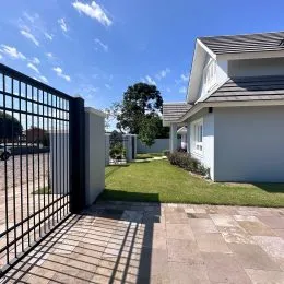 Fachada de uma residência em Lajeado, Brasil, com portão de metal.