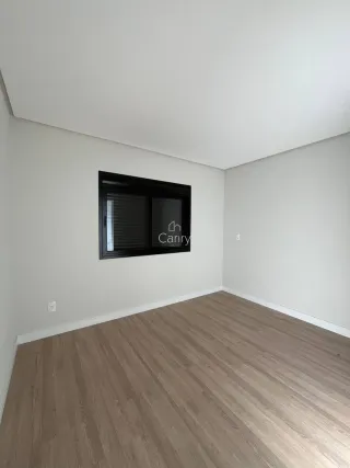 Foto de um cômodo interno com piso de madeira clara e paredes brancas.