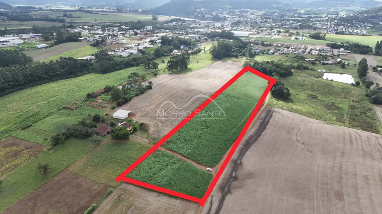 Vista aérea de uma propriedade rural com campos verdes e área de terra.