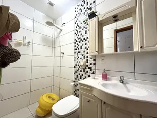 Foto de um banheiro com revestimento branco e preto.
