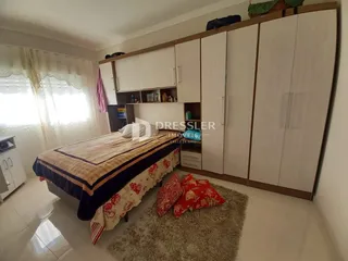 Quarto com armários embutidos e cama no centro do ambiente.