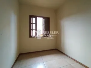 Uma sala interna com paredes claras e piso de cerâmica é visível.