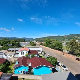 Vista externa de uma rua residencial com casas e vegetação em Lajeado, Brasil.