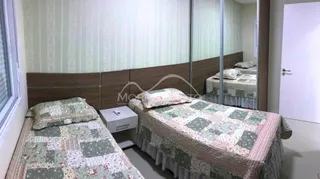 Quarto com duas camas de casal e roupa de cama estampada.
