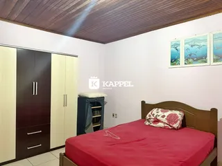 Quarto com cama de madeira e armário em ambiente claro.