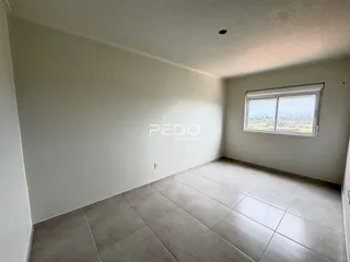 Ambiente interno com piso de cerâmica claro e paredes brancas.
