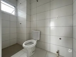 Interior de um banheiro com revestimento cerâmico branco.