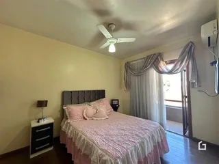 Quarto com cama e cortinas em um imóvel no Brasil.