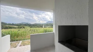 Vista de um campo verde com montanhas ao fundo.