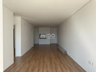 Corredor interno de uma residência com piso de madeira clara.