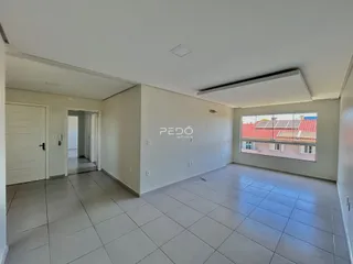 Ambiente interno de uma sala com piso de cerâmica e parede branca em uma residência.