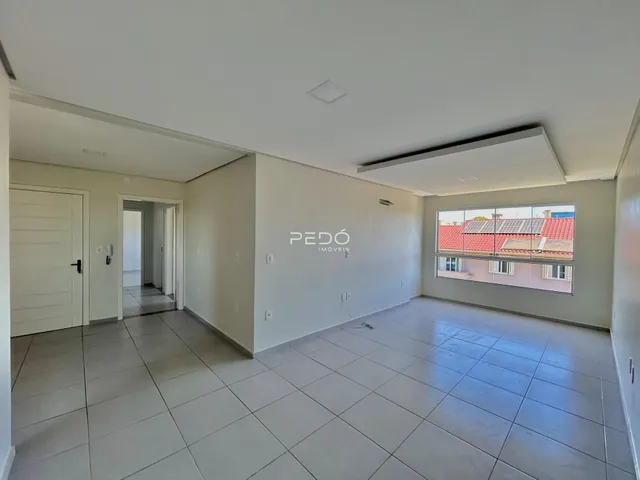 Ambiente interno de uma sala com piso de cerâmica e parede branca em uma residência.