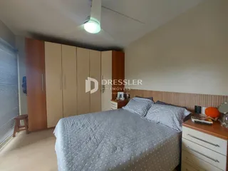 Quarto com armários em madeira e cama de casal.