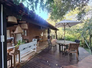 Deck de madeira com mesa e cadeiras no exterior.