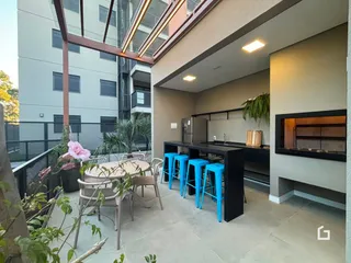Uma área externa com mesa de jantar e balcão em um apartamento.