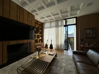 Sala de estar moderna com pé direito alto e grandes janelas.