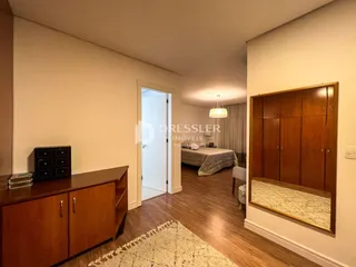 Vista interna de um corredor com piso de madeira e armários de madeira.
