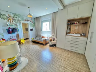 Sala de estar com piso de madeira clara e paredes brancas.