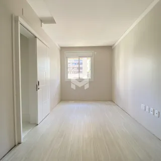 Ambiente interno de uma área de circulação com piso de madeira clara.