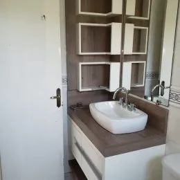 Foto de um banheiro com bancada e espelho.