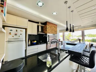 Cozinha moderna com armários brancos e bancadas escuras em uma residência.