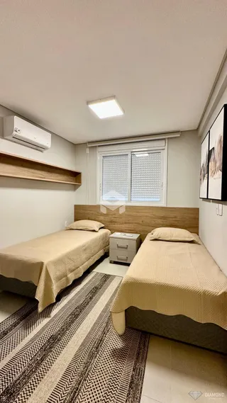 Quarto com duas camas de solteiro e cabeceiras de madeira.